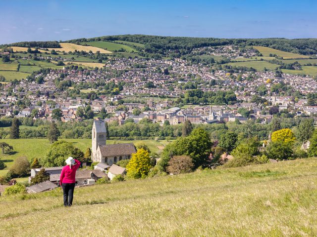 Woman admiring view across to Stroud from Selsley Common, The Cotswolds, Gloucestershire,England, United Kingdom